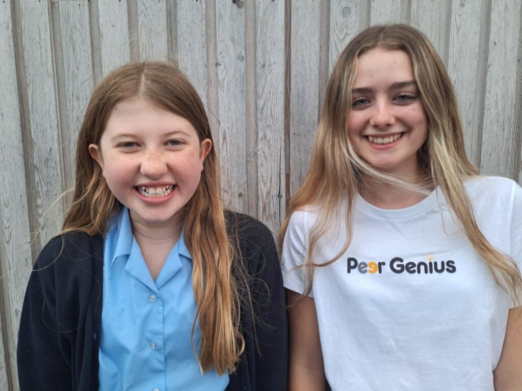 Tutor and student standing in front of a wall outside