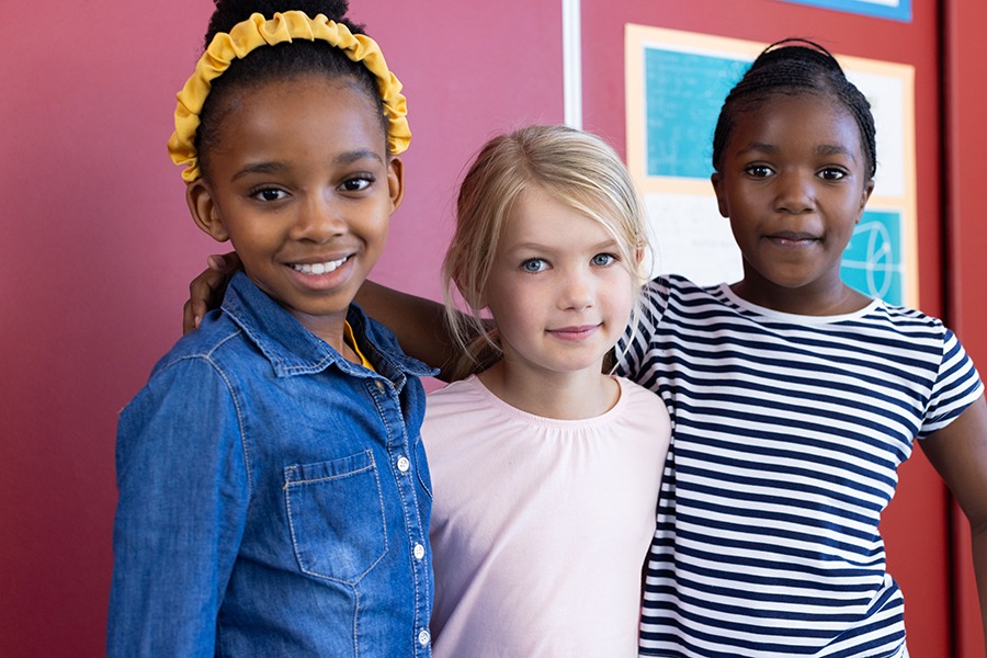 Multiracial school children standing together smiling